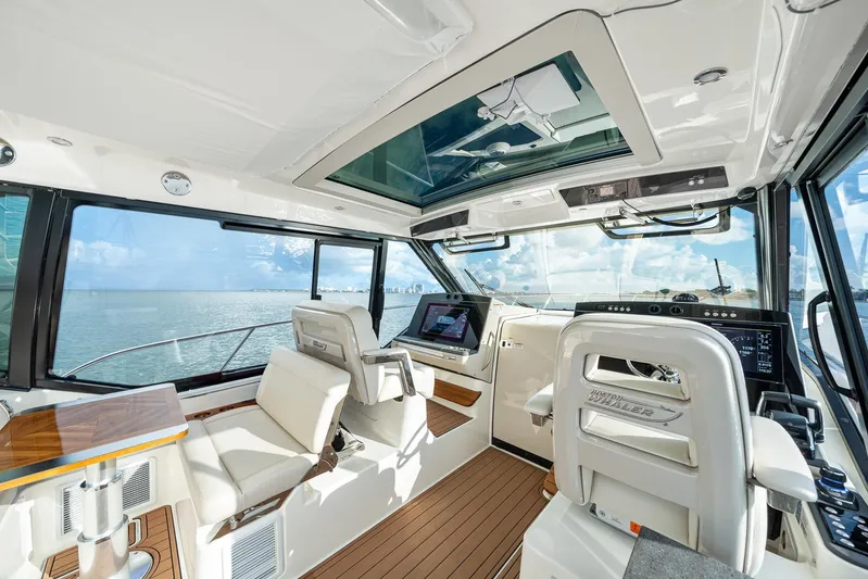  Yacht Photos Pics 2024 Boston Whaler 405 Conquest interior with modern helm, luxurious seating, and panoramic ocean view.
