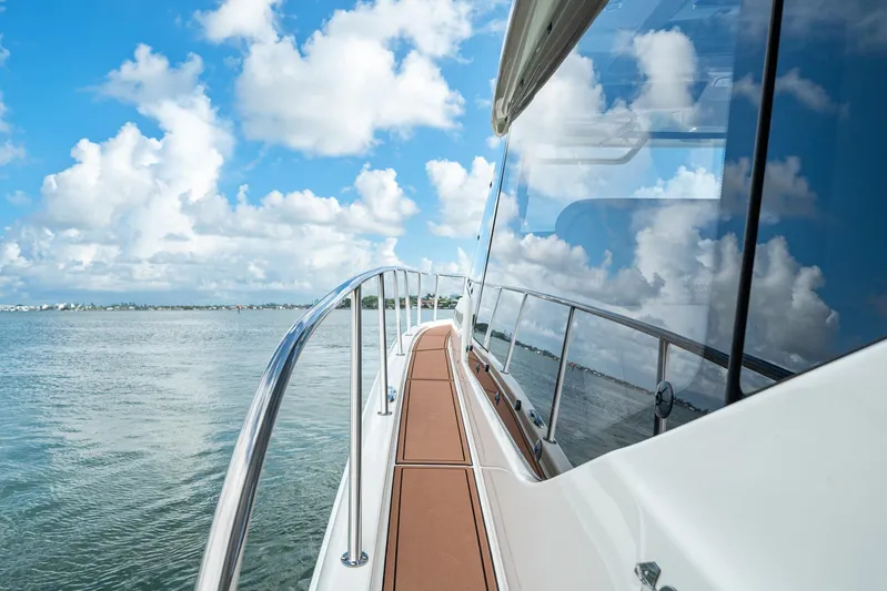  Yacht Photos Pics 2024 Boston Whaler 405 Conquest yacht on calm waters under a blue sky.