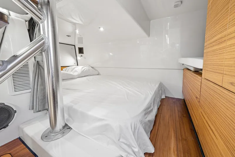  Yacht Photos Pics 2024 Boston Whaler 405 Conquest cabin interior with bed and wooden cabinetry.