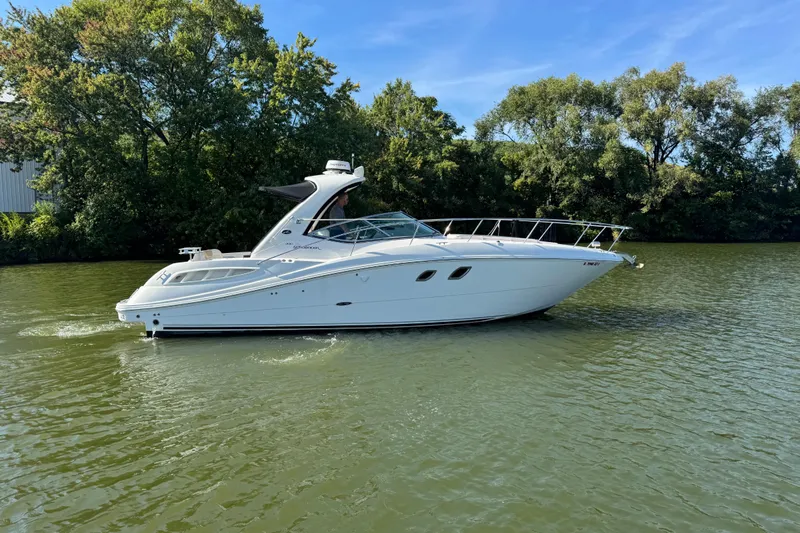  Yacht Photos Pics 2008 Sea Ray 350 Sundancer cruising on a calm river with lush green trees.