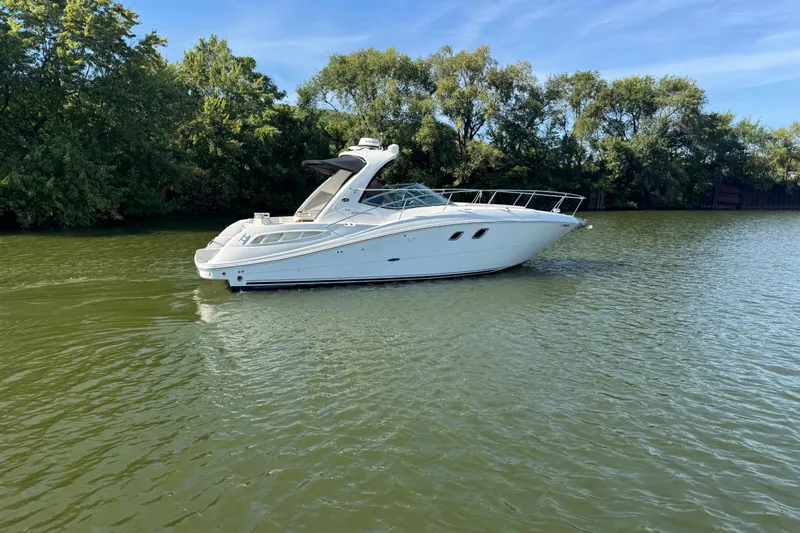  Yacht Photos Pics 2008 Sea Ray 350 Sundancer yacht cruising on a serene lake with lush greenery.