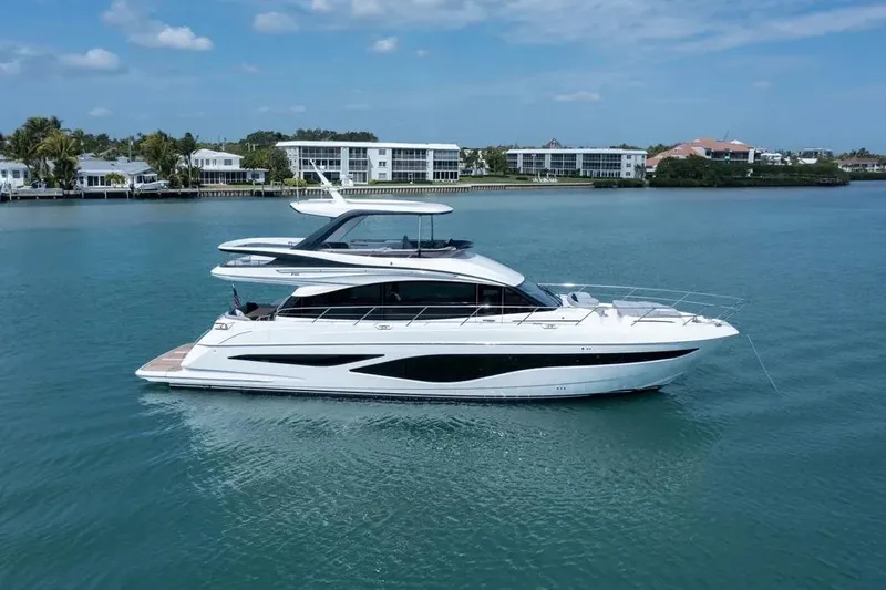  Yacht Photos Pics Luxurious 2026 Princess F65 yacht cruising on serene blue waters near coastal homes.