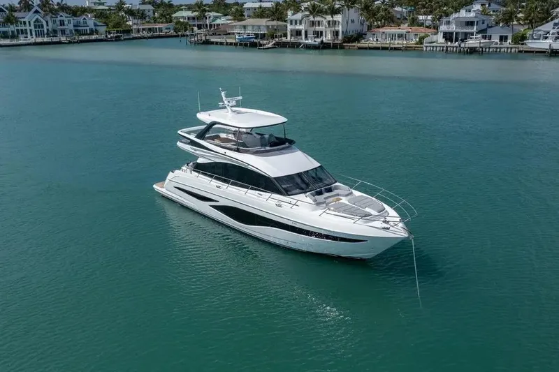  Yacht Photos Pics 2026 Princess F65 yacht on serene water near luxury waterfront homes.