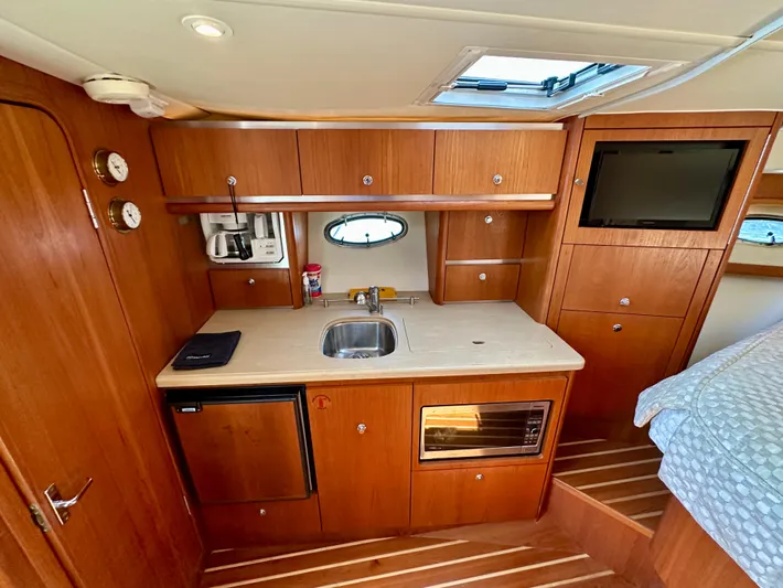  Yacht Photos Pics 2004 Tiara Yachts 3200 Open interior with kitchenette, sink, microwave, and wooden cabinetry.
