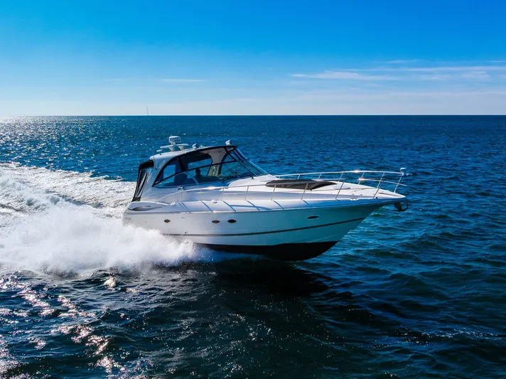 Escape Yacht Photos Pics 2005 Cruisers Yachts 440 Express speeding on open sea under clear blue sky.
