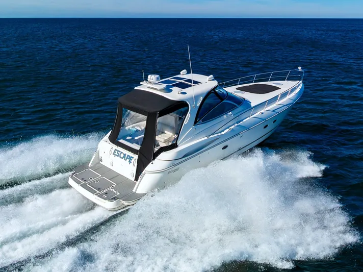 Escape Yacht Photos Pics 2005 Cruisers Yachts 440 Express speeding on open water, creating waves.