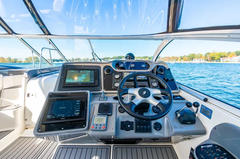 Escape Yacht Photos Pics Helm of 2005 Cruisers Yachts 440 Express with navigation screens and steering wheel.