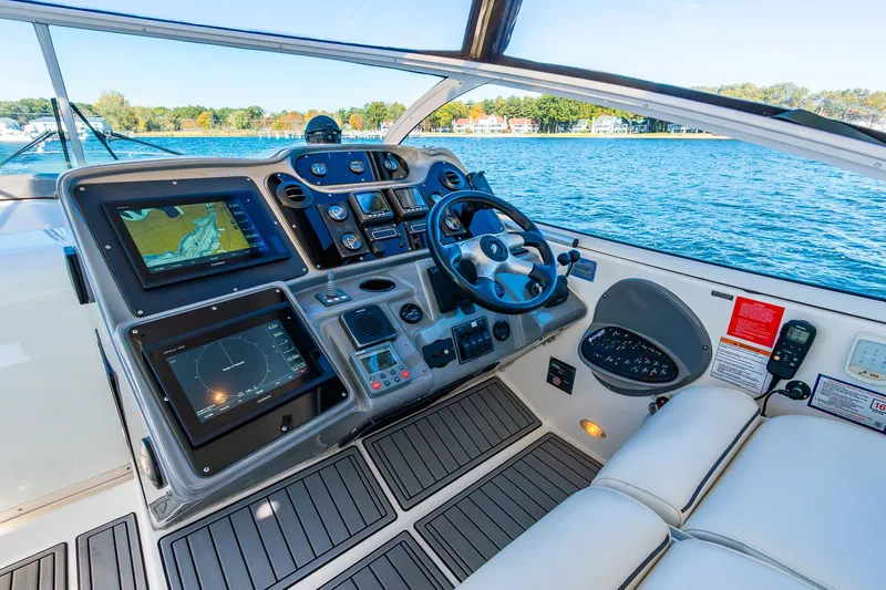 Escape Yacht Photos Pics Helm of 2005 Cruisers Yachts 440 Express with navigation screens and steering wheel.