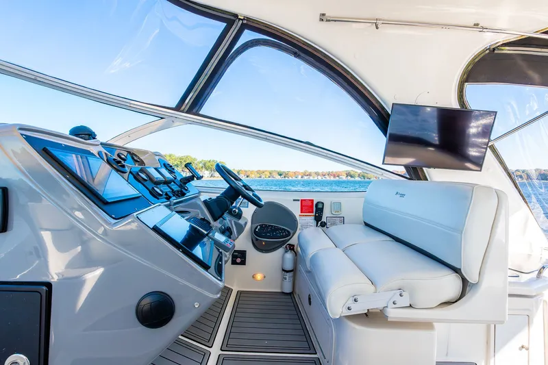 Escape Yacht Photos Pics 2005 Cruisers Yachts 440 Express helm with modern controls and seating, overlooking scenic water view.