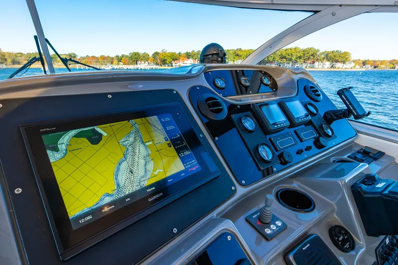Escape Yacht Photos Pics 2005 Cruisers Yachts 440 Express dashboard with navigation system, on a scenic waterway.