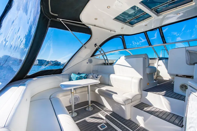 Escape Yacht Photos Pics Luxurious interior of 2005 Cruisers Yachts 440 Express with white seating and panoramic windows.