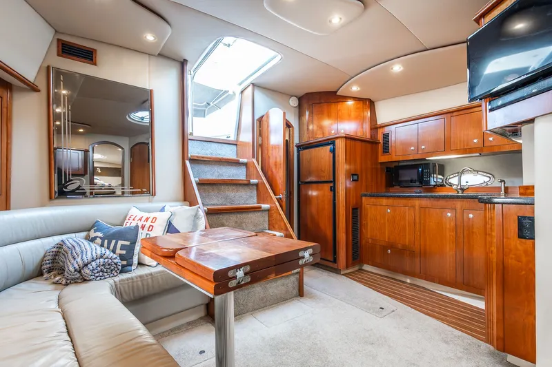 Escape Yacht Photos Pics Luxurious interior of 2005 Cruisers Yachts 440 Express with elegant wood cabinetry and cozy seating.