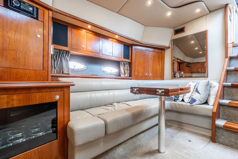 Escape Yacht Photos Pics Luxurious interior of 2005 Cruisers Yachts 440 Express with plush seating and wooden cabinetry.