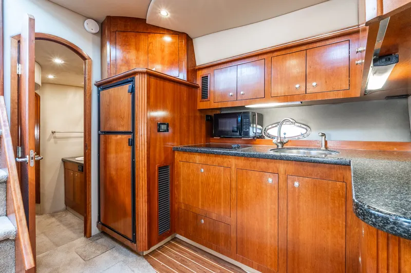 Escape Yacht Photos Pics 2005 Cruisers Yachts 440 Express interior with wooden cabinetry and modern kitchen amenities.
