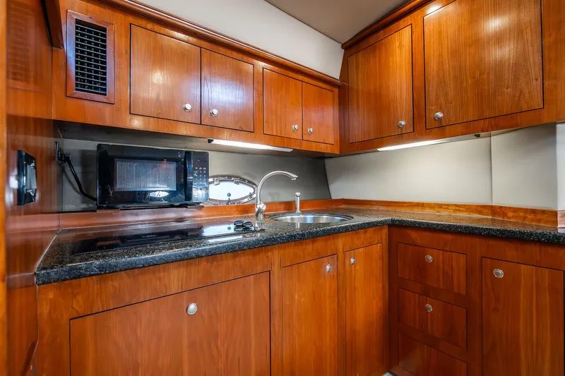 Escape Yacht Photos Pics Luxurious 2005 Cruisers Yachts 440 Express kitchen with wood cabinets and modern appliances.