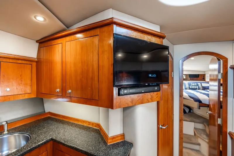 Escape Yacht Photos Pics Luxurious 2005 Cruisers Yachts 440 Express interior with TV, wooden cabinets, and cozy bedroom.