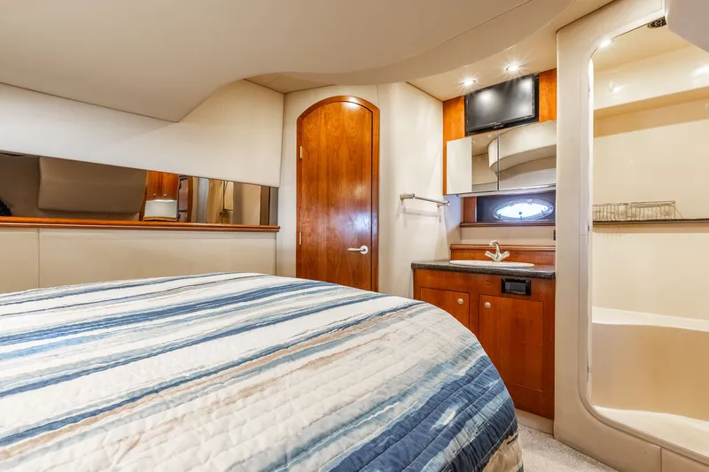 Escape Yacht Photos Pics Luxurious cabin interior of 2005 Cruisers Yachts 440 Express with bed, sink, and TV.