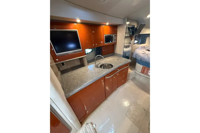 Dream Maker II Yacht Photos Pics 2005 Formula 37 Performance Cruiser interior with kitchenette, TV, and bed.