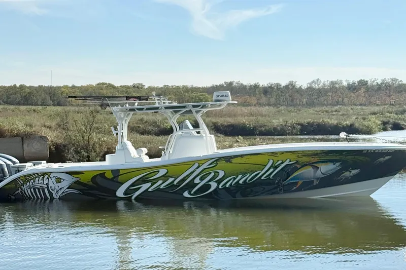  Yacht Photos Pics 2016 Yellowfin 36 Offshore boat with vibrant "Gulf Bandit" graphics on calm water.