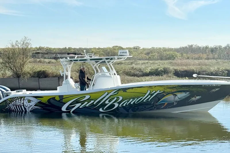  Yacht Photos Pics 2016 Yellowfin 36 Offshore boat with vibrant "Gulf Bandit" graphics on calm water.