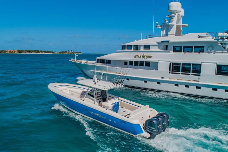 Starship Yacht Photos Pics A 1988 Van Mill Custom yacht cruising alongside a smaller blue and white boat in clear waters.