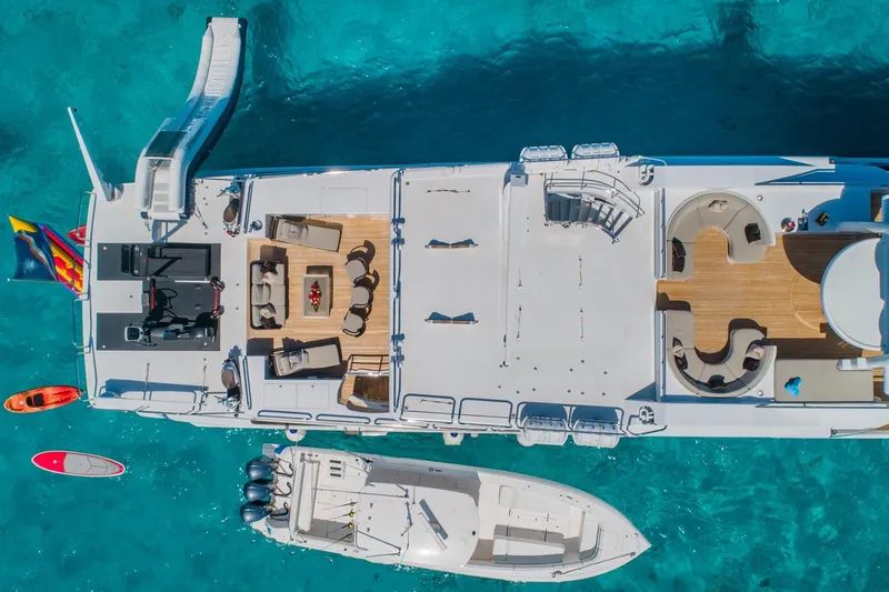 Starship Yacht Photos Pics Aerial view of 1988 Van Mill Custom yacht with slide, kayaks, and tender in turquoise water.