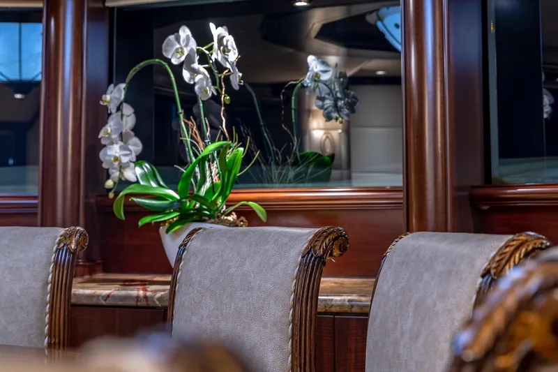 Starship Yacht Photos Pics Luxurious Van Mill 1988 yacht interior with elegant chairs and decorative orchids.