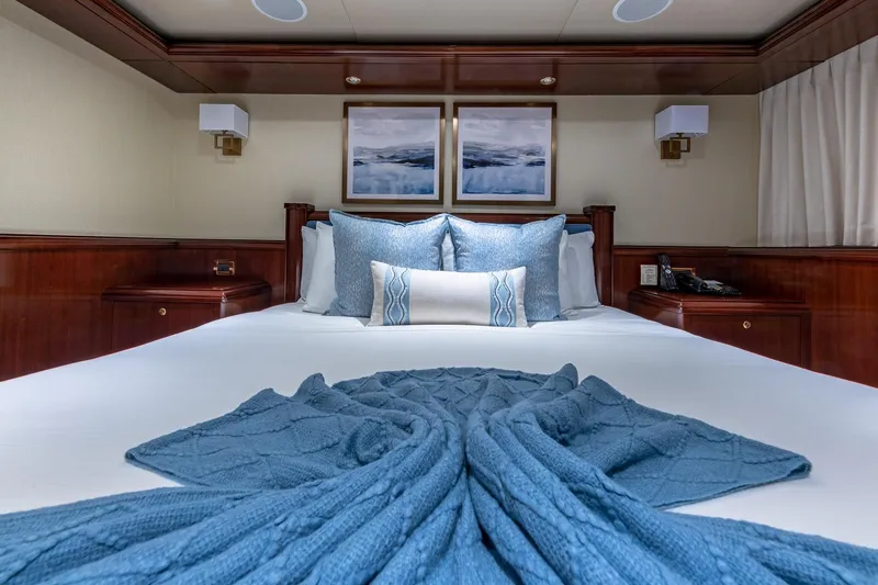 Starship Yacht Photos Pics Luxurious 1988 Van Mill Custom yacht bedroom with elegant blue bedding and wooden accents.