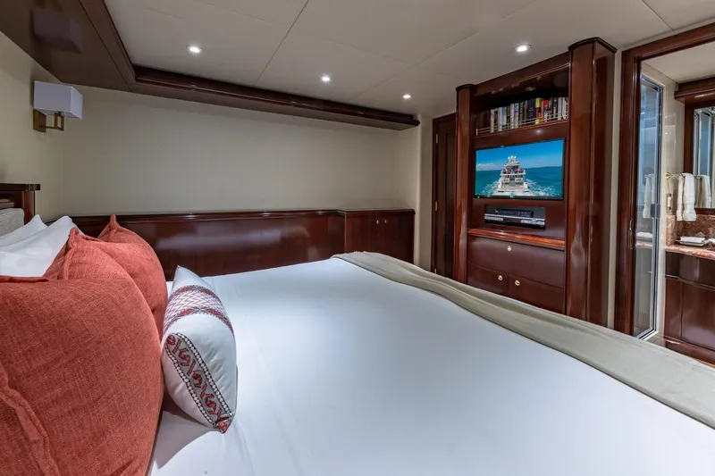 Starship Yacht Photos Pics Luxurious 1988 Van Mill Custom yacht bedroom with TV, elegant wood finishes, and plush bedding.