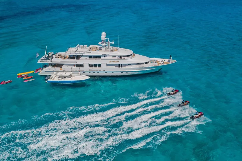 Starship Yacht Photos Pics Luxury yacht "Van Mill Custom 1988" with jet skis in turquoise ocean.
