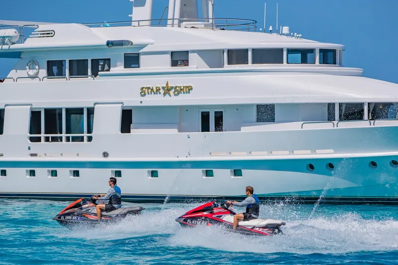 Starship Yacht Photos Pics Two people on jet skis near a 1988 Van Mill Custom yacht named "Star Ship."