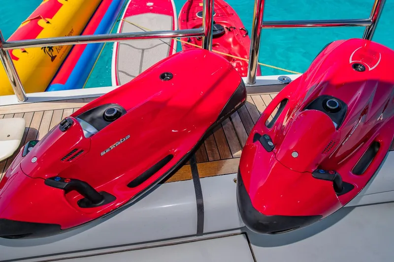 Starship Yacht Photos Pics Red Seabob water scooters on a yacht deck, with vibrant water sports equipment nearby.