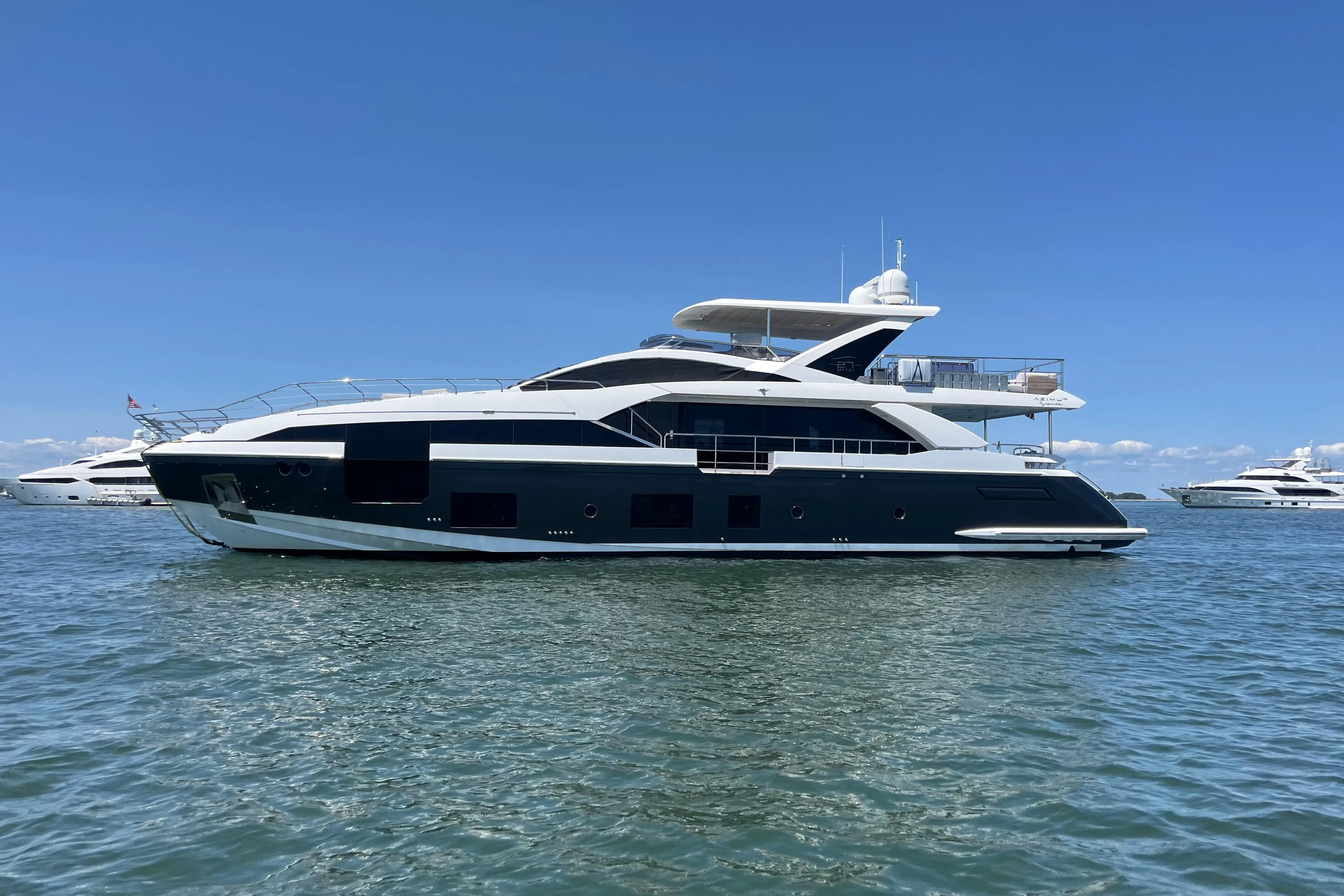 2019 Azimut Grande 27M yacht on calm water under clear blue sky.