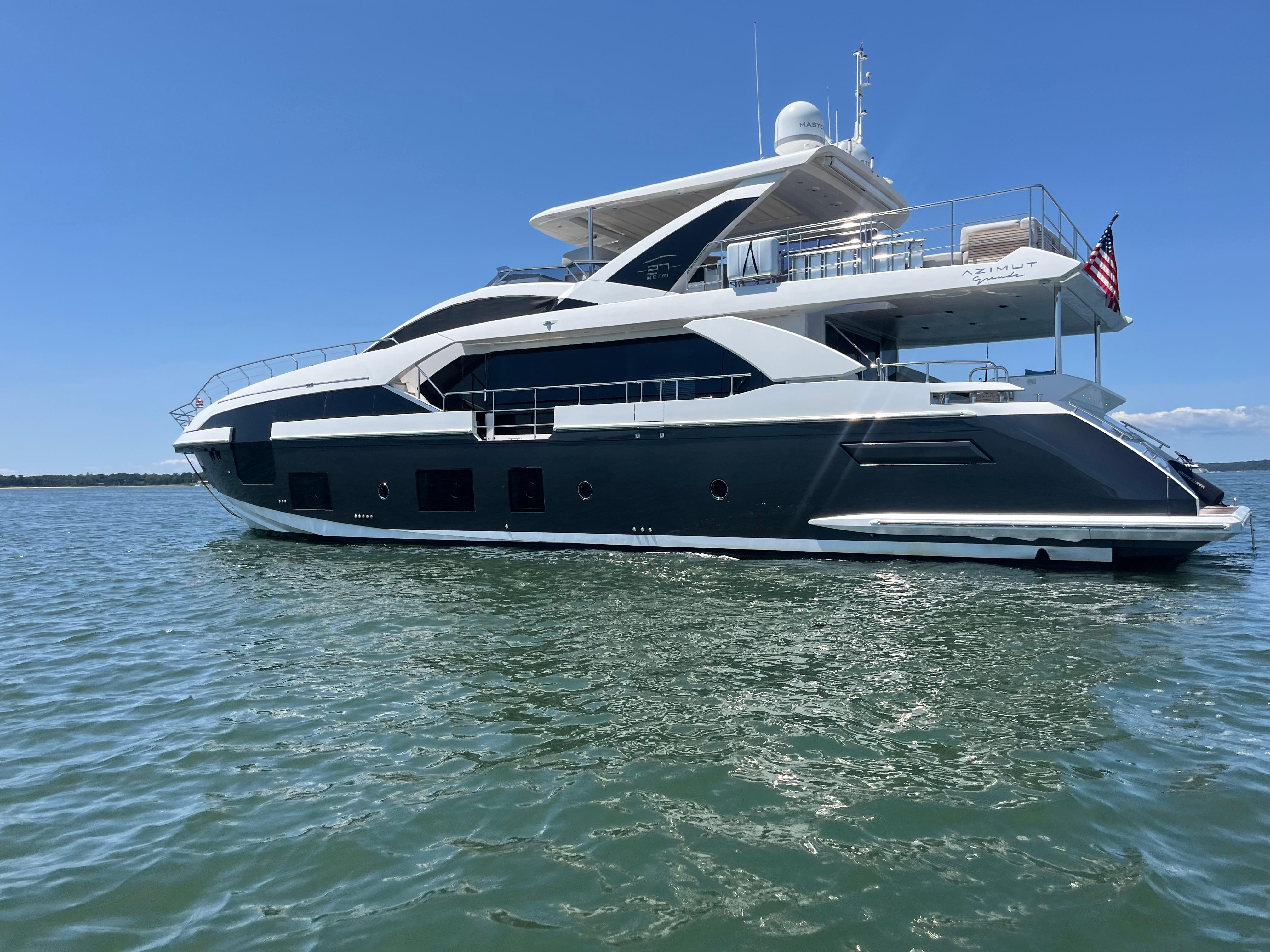 Luxury 2019 Azimut Grande 27M yacht on calm water under clear blue sky.