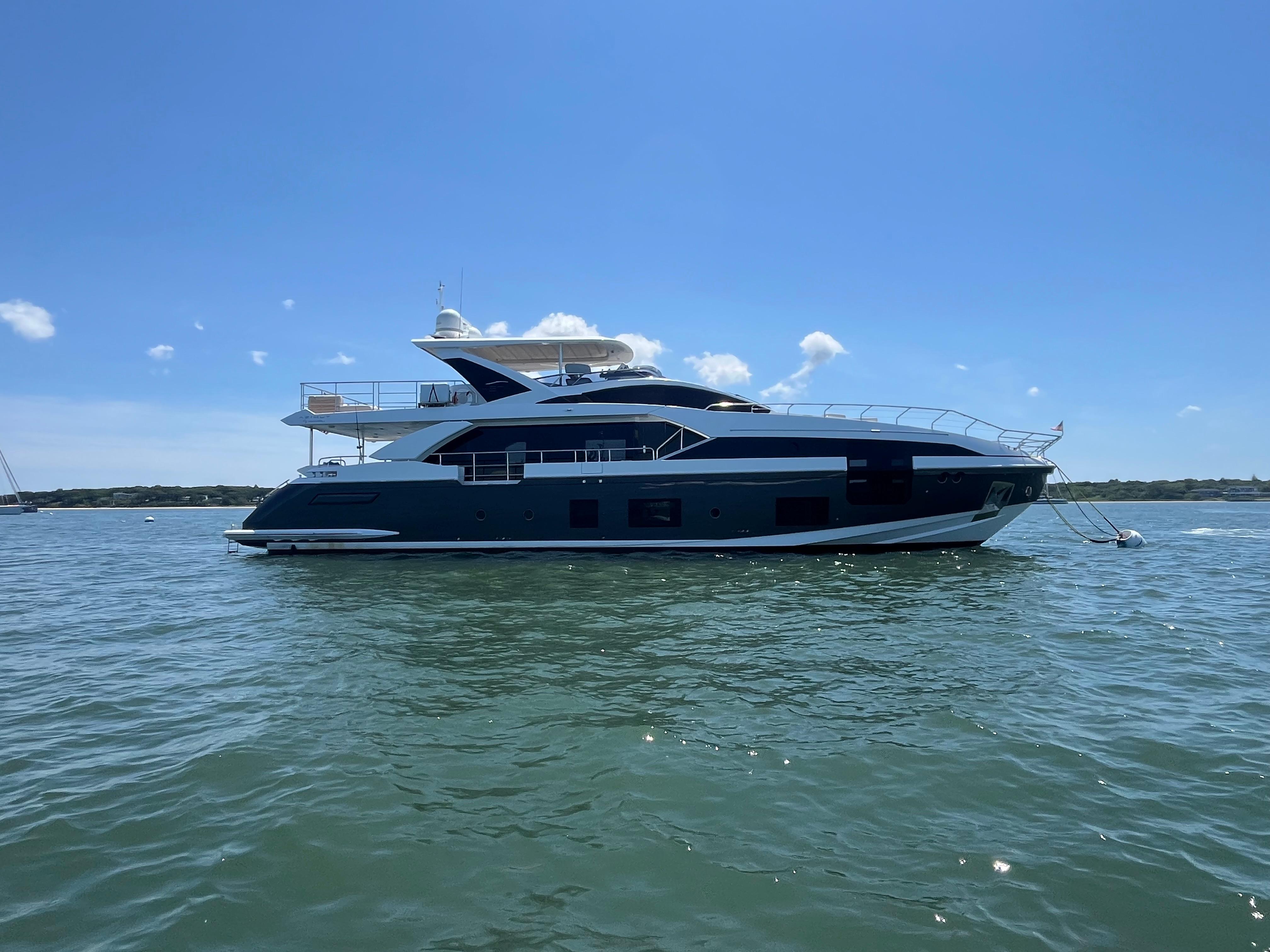 2019 Azimut Grande 27M yacht on calm water under clear blue sky.