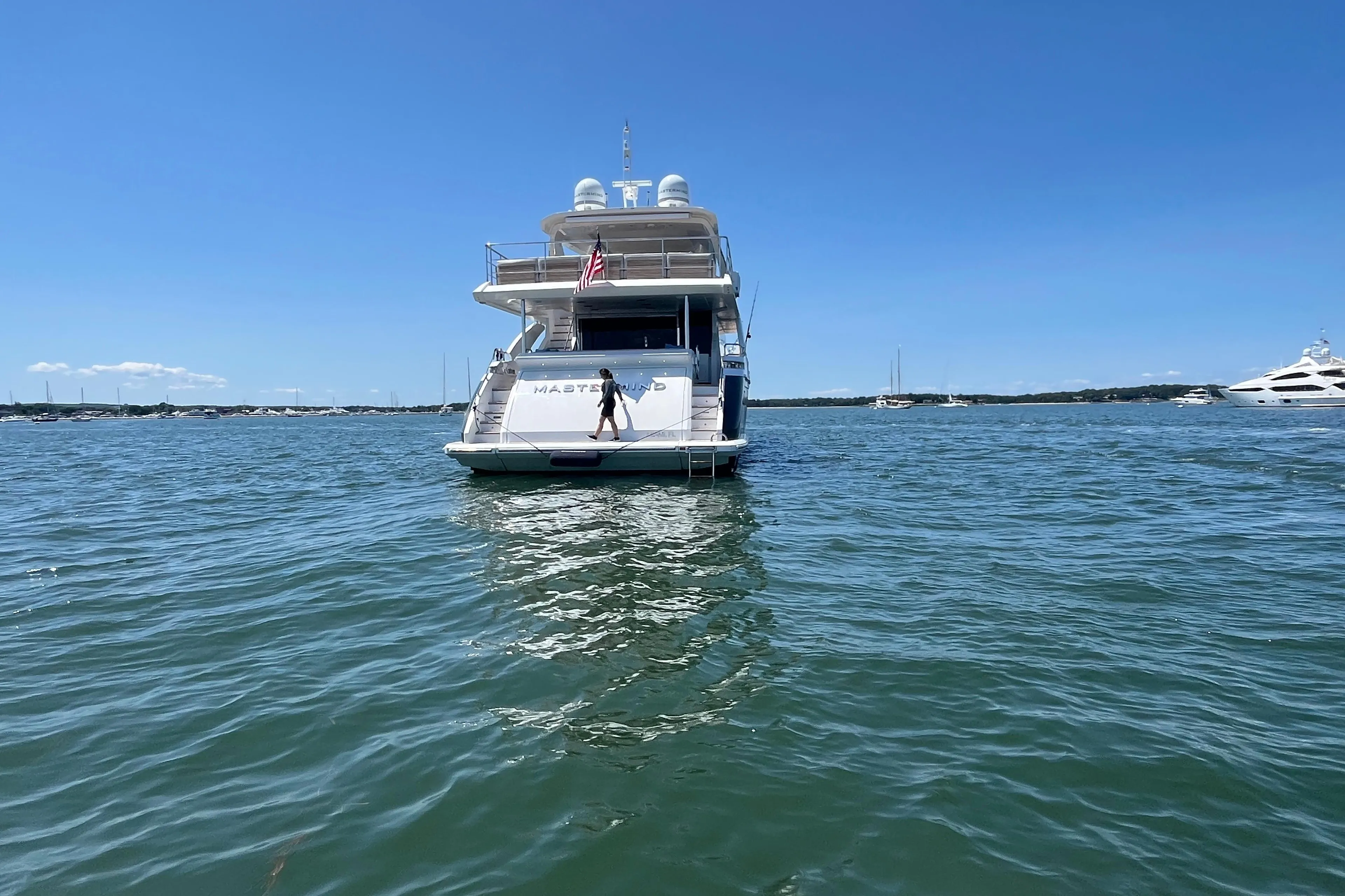 Azimut Grande 27M yacht on water, 2019 model, clear blue sky background.