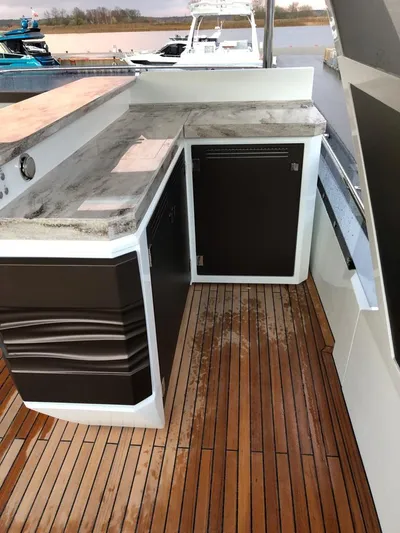  Yacht Photos Pics Galeon 680 Fly 2020 yacht deck with sleek outdoor kitchen and wooden flooring.