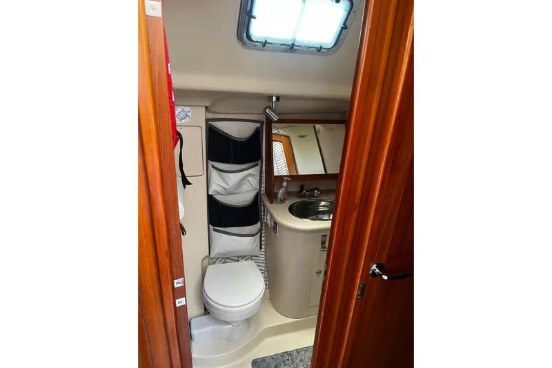 Honu Yacht Photos Pics Bathroom interior of 2006 Hunter 41 Deck Salon yacht, featuring toilet and sink.