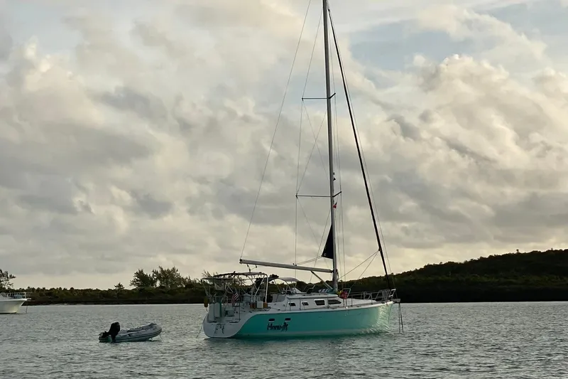 Honu Yacht Photos Pics Sailboat Hunter 41 Deck Salon 2006 anchored on calm water under cloudy sky.