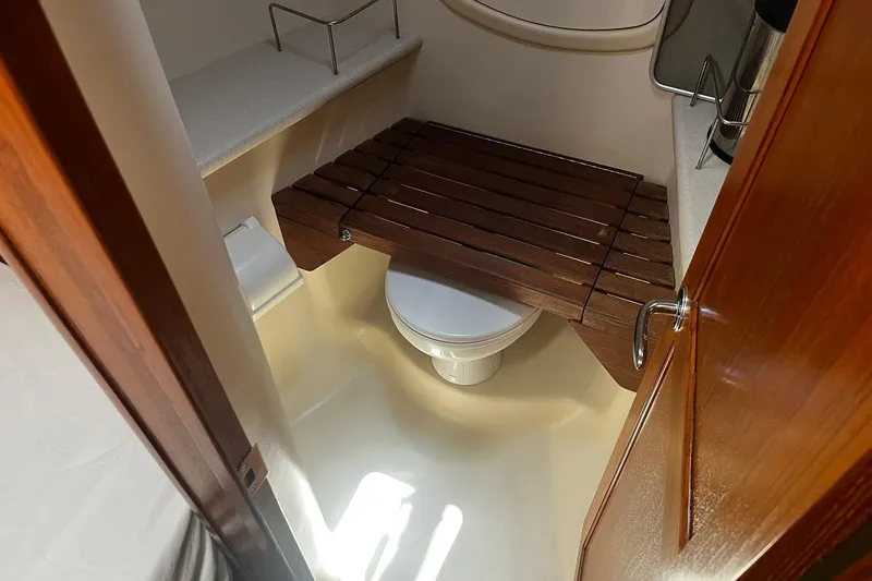 Honu Yacht Photos Pics Bathroom interior of 2006 Hunter 41 Deck Salon yacht with wooden seat and toilet.