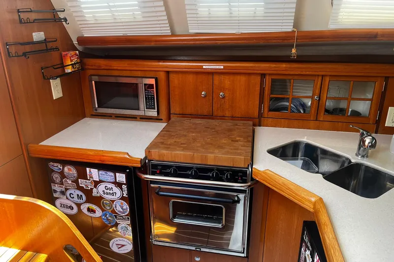 Honu Yacht Photos Pics Galley kitchen in 2006 Hunter 41 Deck Salon yacht with microwave, stove, and sink.