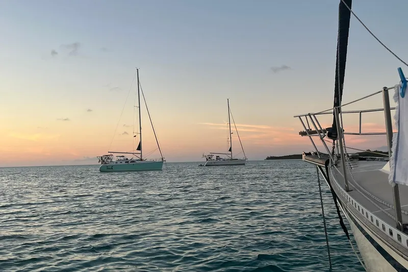 Honu Yacht Photos Pics Sailboats on calm sea at sunset, featuring a 2006 Hunter 41 Deck Salon.