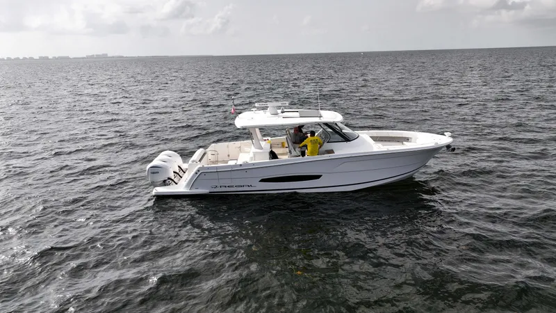  Yacht Photos Pics 2023 Regal 38 SAV boat cruising on open water under cloudy skies.