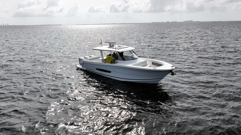  Yacht Photos Pics 2023 Regal 38 SAV boat cruising on open water under cloudy sky.