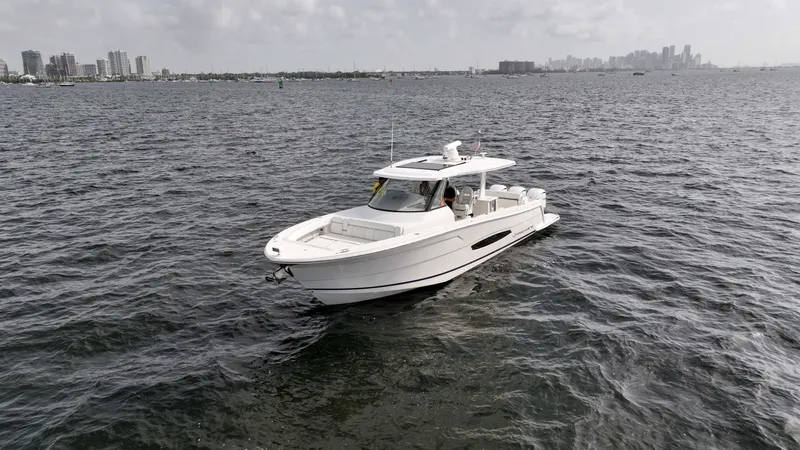  Yacht Photos Pics 2023 Regal 38 SAV boat cruising on open water with city skyline in background.