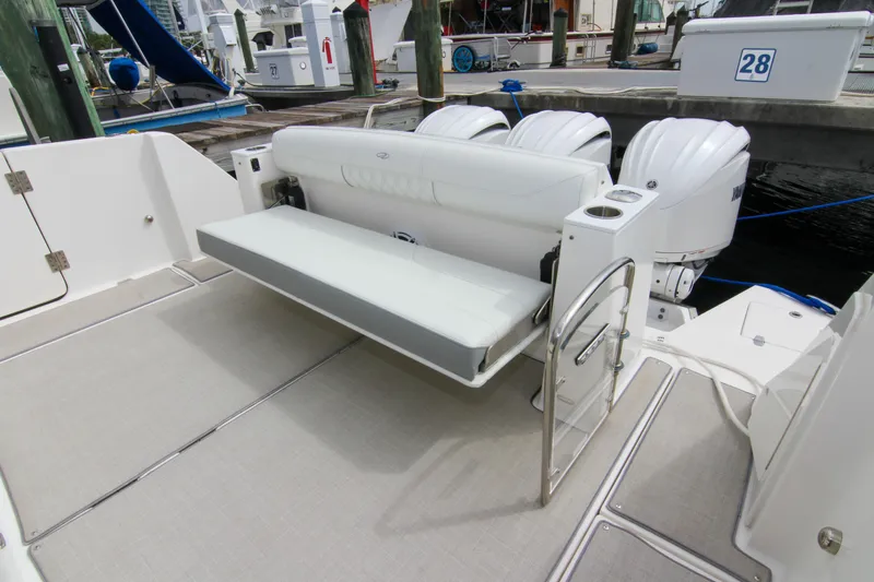  Yacht Photos Pics 2023 Regal 38 SAV boat with foldable seating and triple outboard engines at dock.