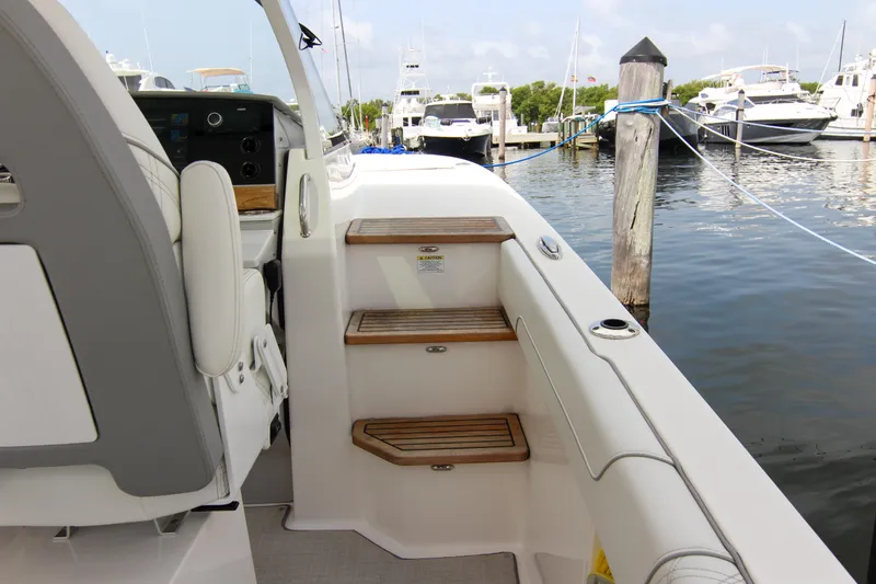  Yacht Photos Pics 2023 Regal 38 SAV boat interior with wooden steps, docked at marina.