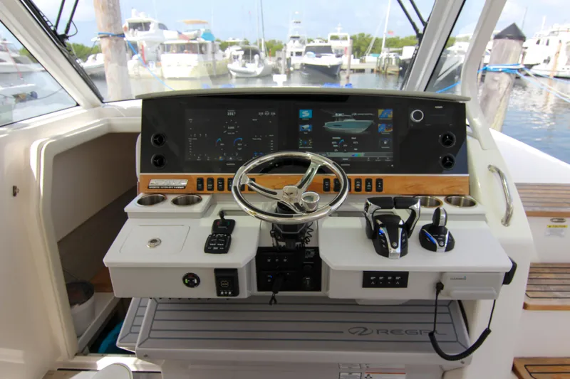  Yacht Photos Pics 2023 Regal 38 SAV helm with advanced controls and navigation displays in a marina setting.