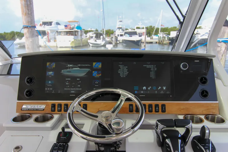  Yacht Photos Pics 2023 Regal 38 SAV helm with advanced navigation displays and controls in a marina setting.