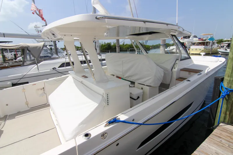  Yacht Photos Pics 2023 Regal 38 SAV luxury boat docked at marina, featuring sleek design and covered seating.